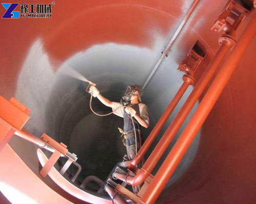 Worker applying polyurea coating inside an industrial storage tank